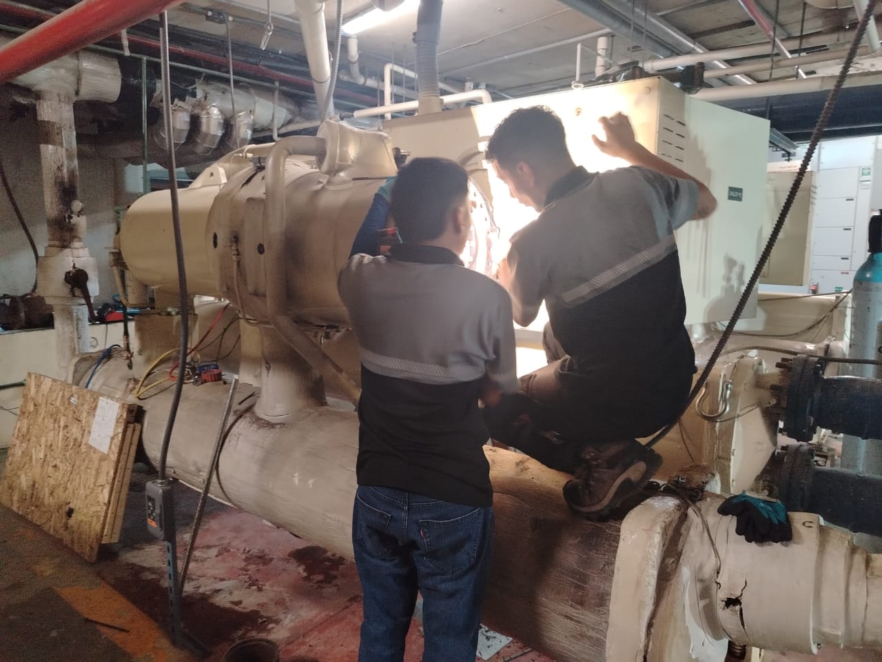 Técnicos de PHES interviniendo un chiller de agua helada en cuarto de máquinas